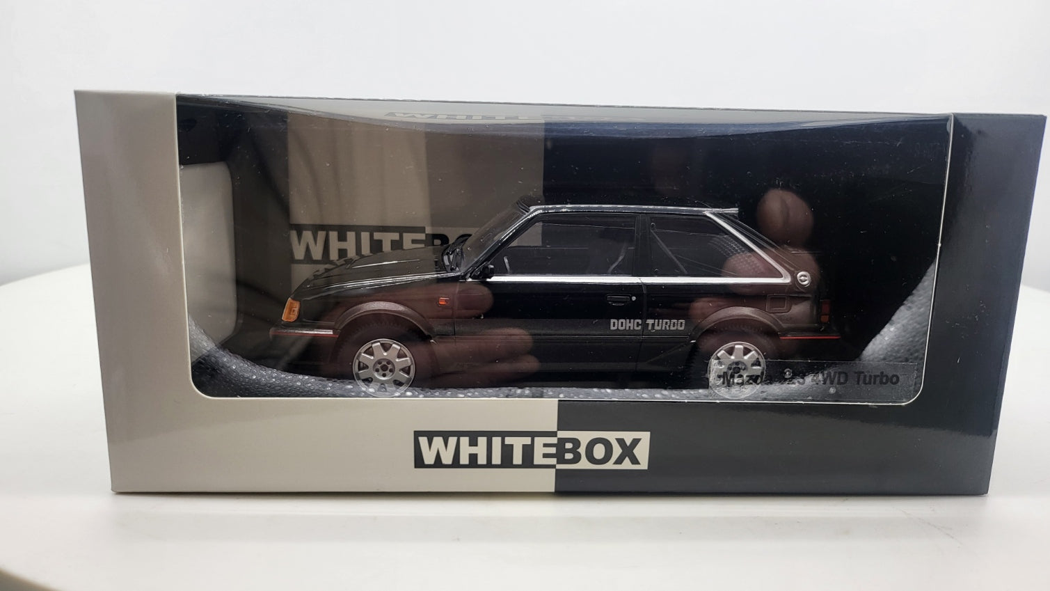 Whitebox Mazda 323 4WD Turbo Zwart/Donkergrijs 1989 - Schaal 1:24
