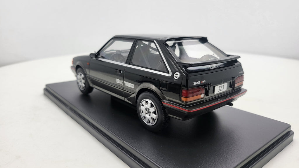 Whitebox Mazda 323 4WD Turbo Zwart/Donkergrijs 1989 - Schaal 1:24