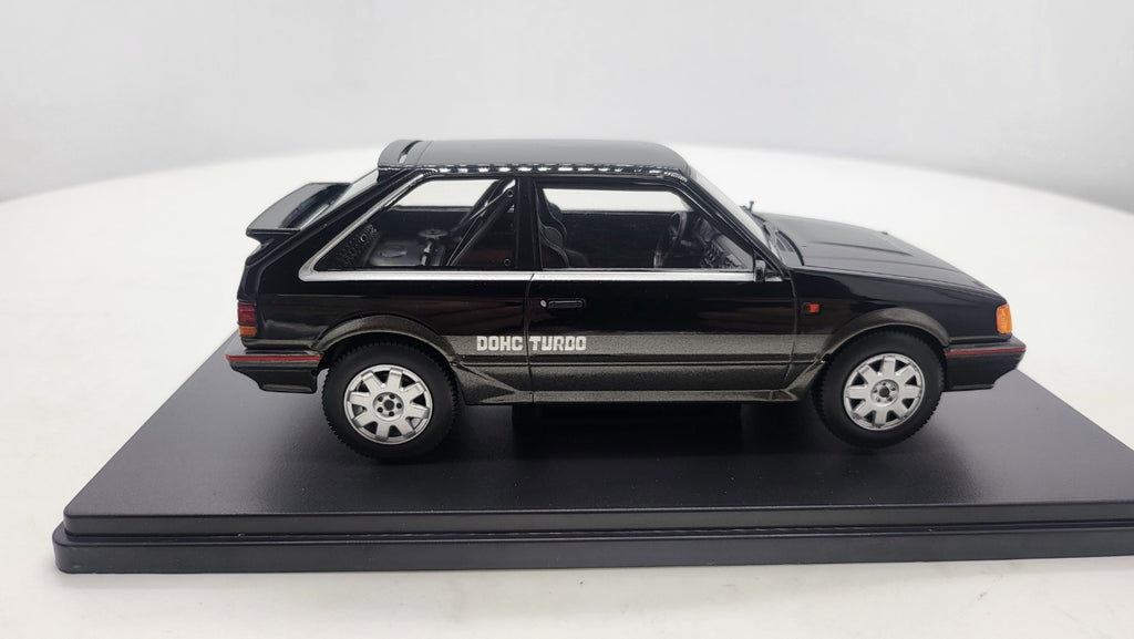 Whitebox Mazda 323 4WD Turbo Zwart/Donkergrijs 1989 - Schaal 1:24