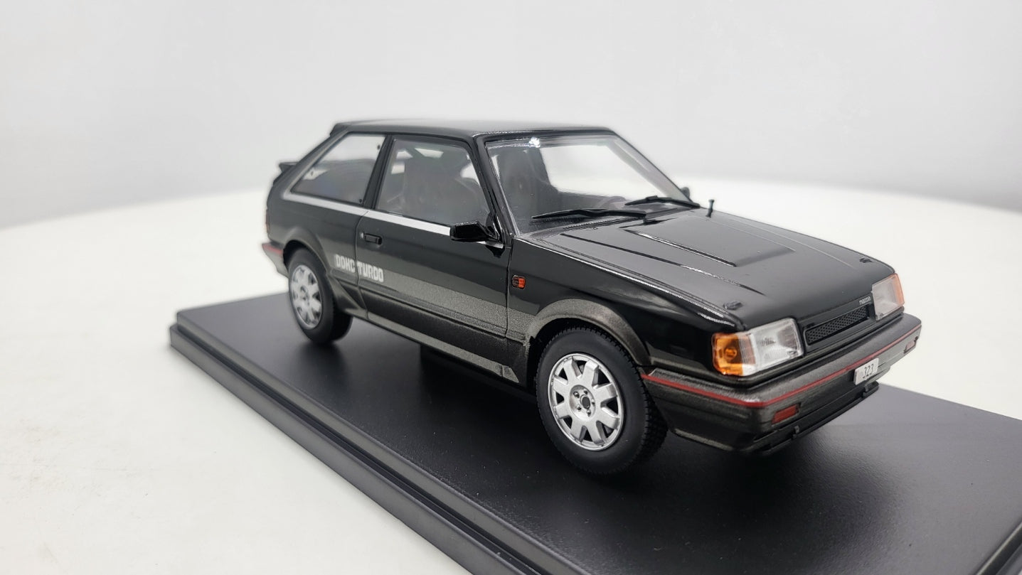 Whitebox Mazda 323 4WD Turbo Zwart/Donkergrijs 1989 - Schaal 1:24